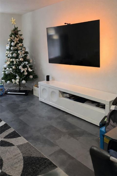 Large-format dark tile flooring and white wall-mounted media console