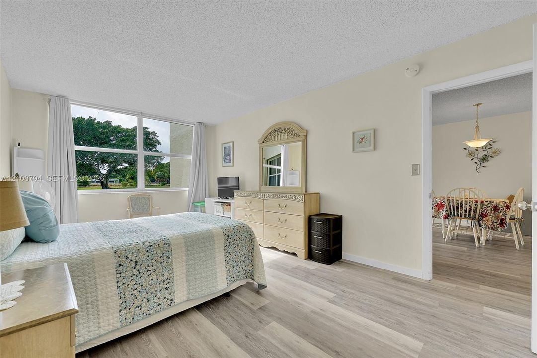 Neutral-toned interior featuring expansive windows, wood-finish flooring, and textured ceiling finish