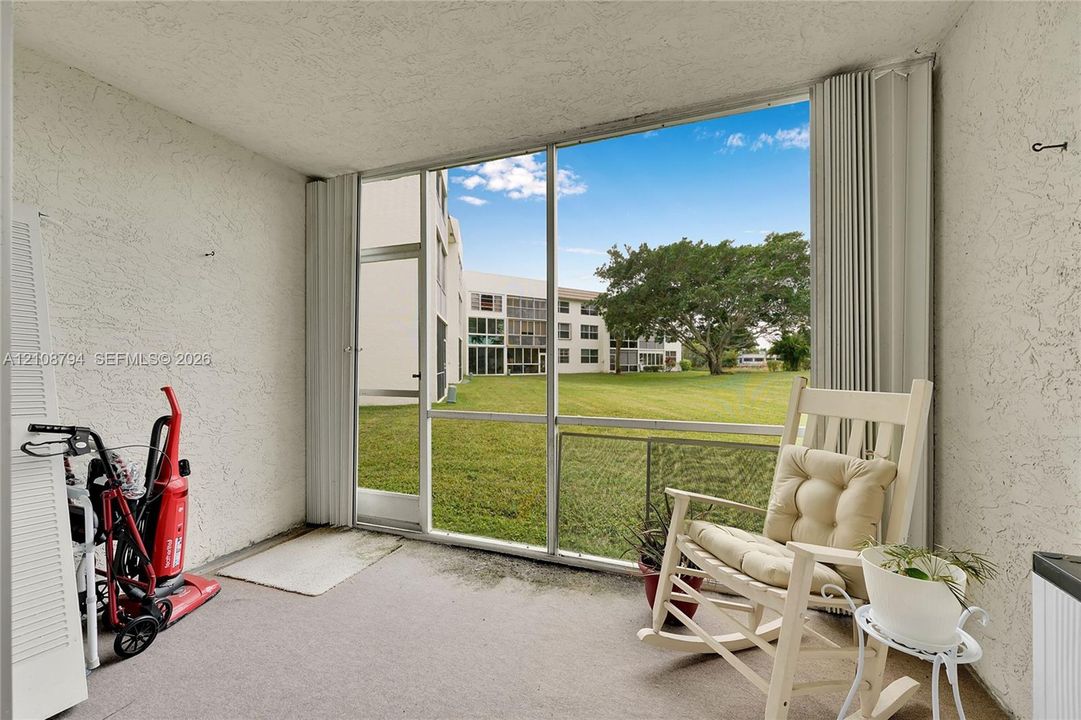 Enclosed lanai featuring screen panels, aluminum framing, textured wall finishes, and concrete flooring