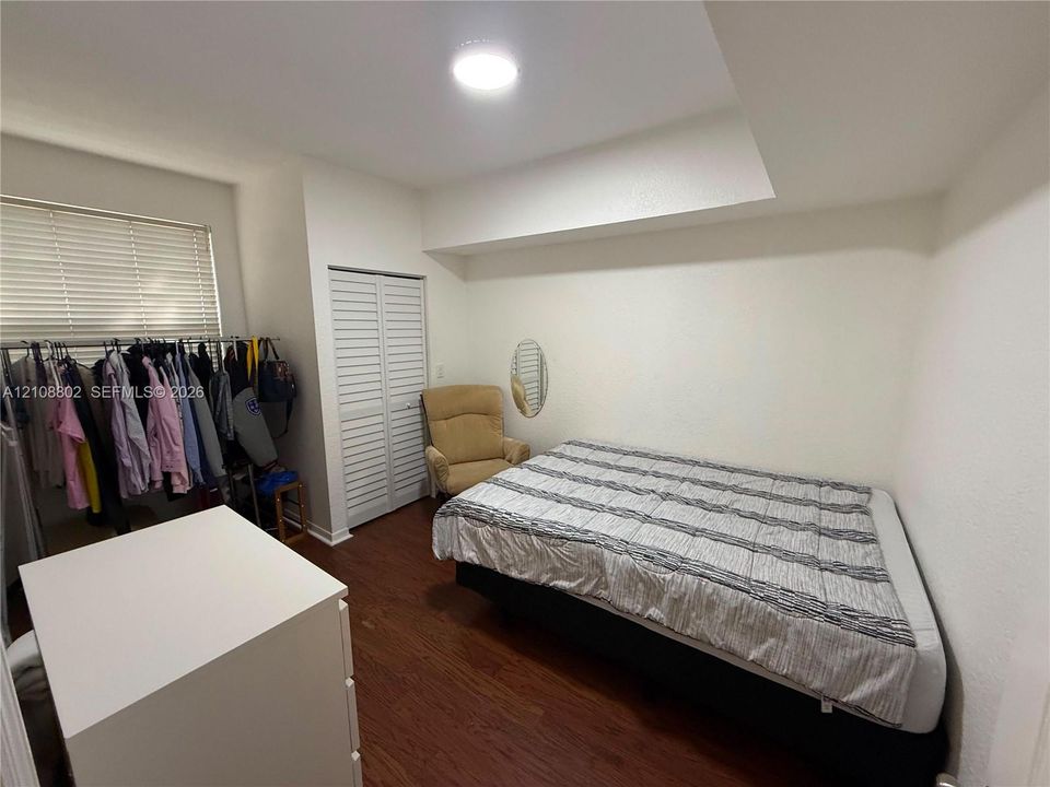 Wood-finish flooring, recessed ceiling design, and a closet with louvered doors