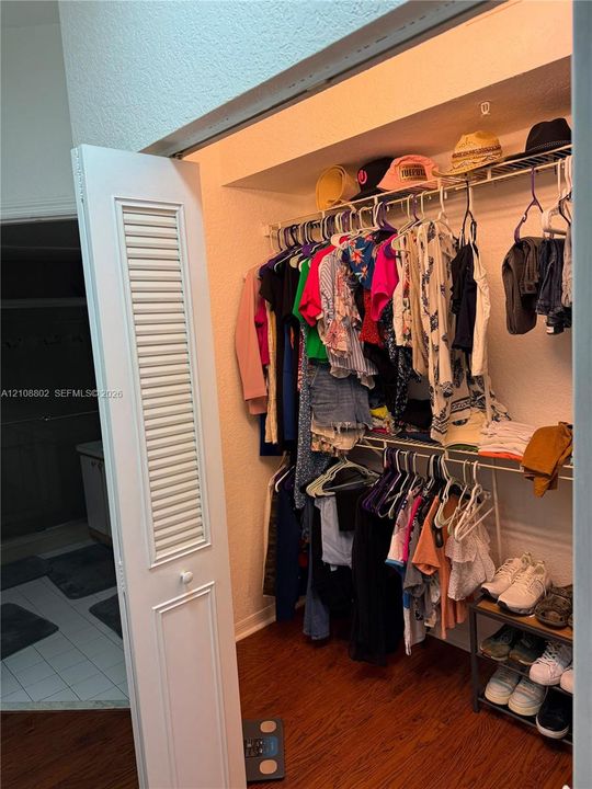Closet featuring louvered bi-fold door, wood-finish flooring, and multi-tier wire shelving