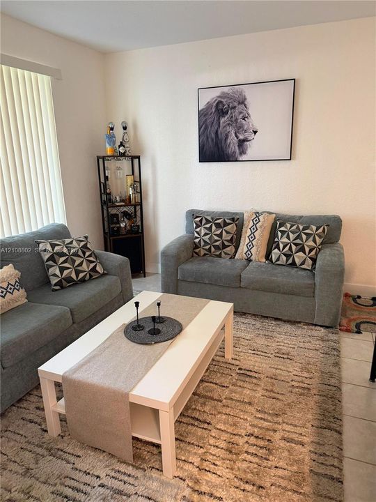 Neutral wall paint, tile flooring, and vertical blinds