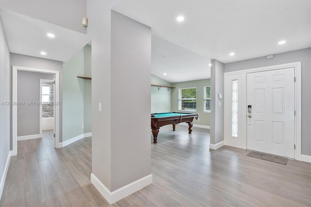 Entryway featuring wood-finish flooring, recessed lighting, and a front door with decorative glass side-lite