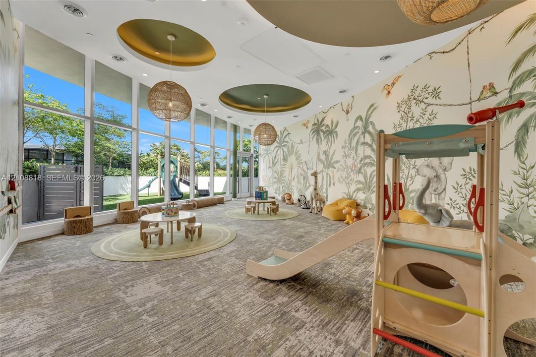 Floor-to-ceiling windows, circular recessed ceiling features with accent lighting, woven pendant light fixtures, and expansive custom wall mural