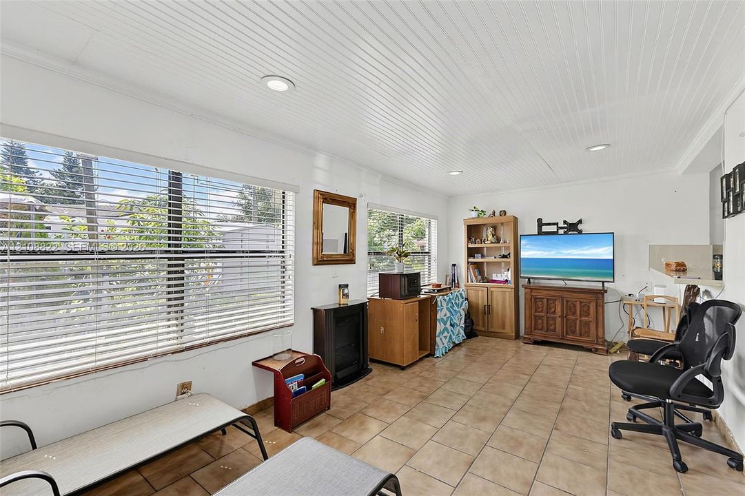 Beadboard ceiling with recessed lighting, large windows with horizontal blinds, and ceramic tile flooring