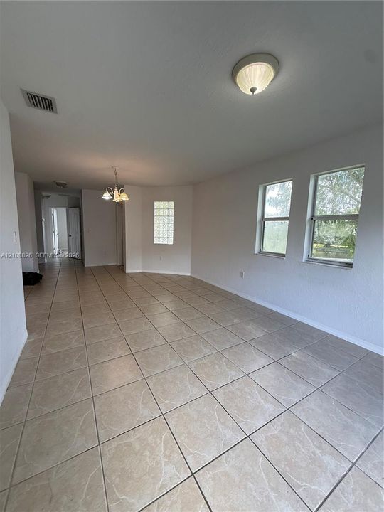 Ceramic tile flooring, neutral wall tones, decorative glass block window accent, and integrated multi-light fixtures