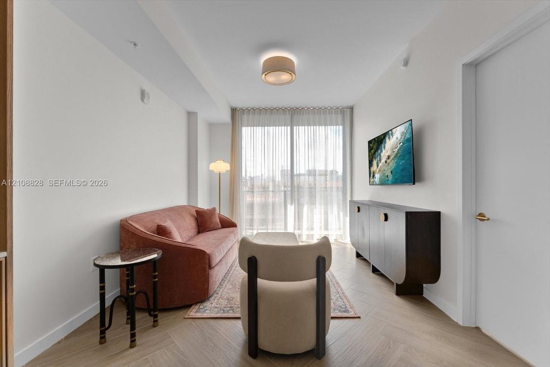 Herringbone-patterned wood-finish flooring, floor-to-ceiling glass sliding door, and recessed ceiling lighting