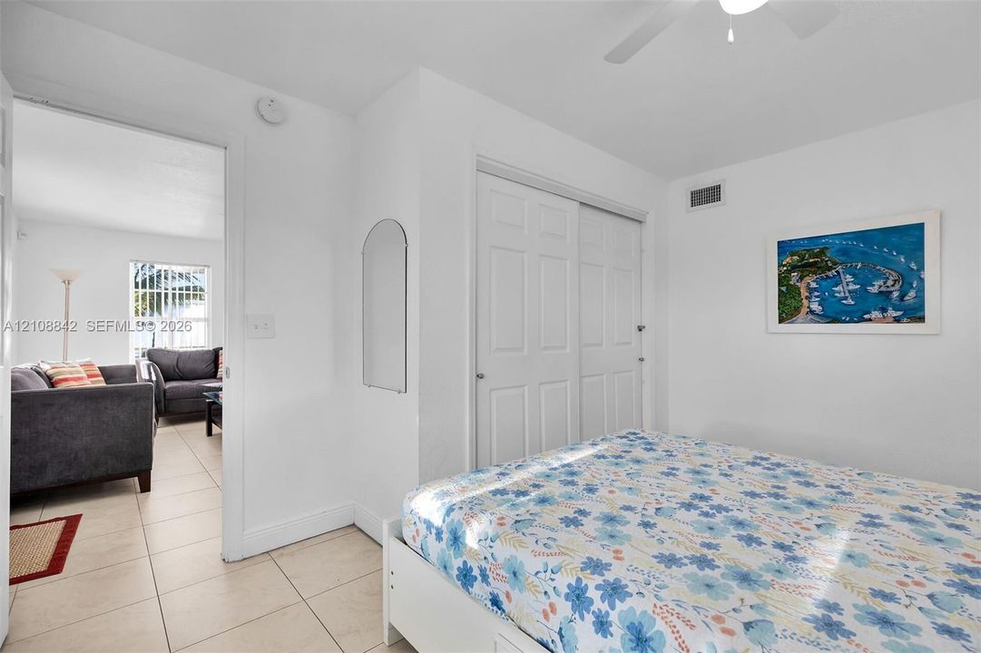 Interior space featuring tile flooring, ceiling fan, and double-door closet with recessed hardware