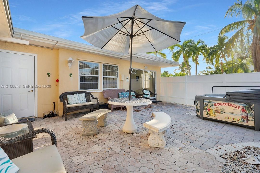 Paver patio featuring a fenced perimeter and a portable hot tub