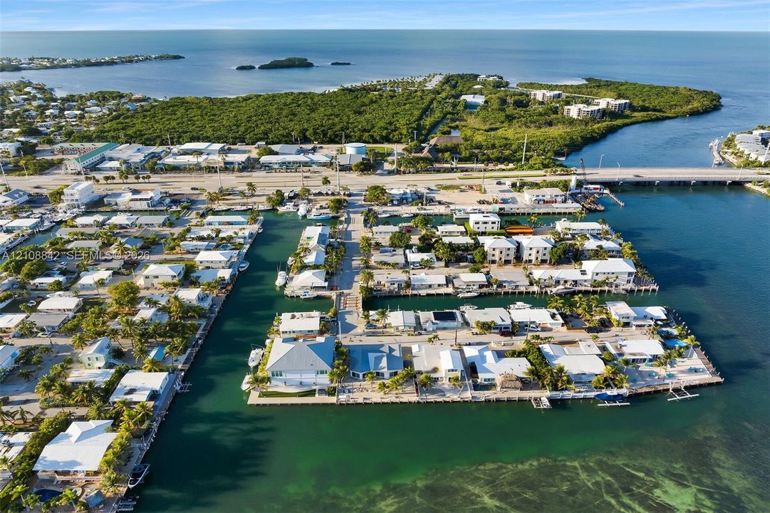Aerial perspective of a coastal peninsula featuring direct deep-water access, private boat docking, waterfront property lines, and proximity to open marine channels