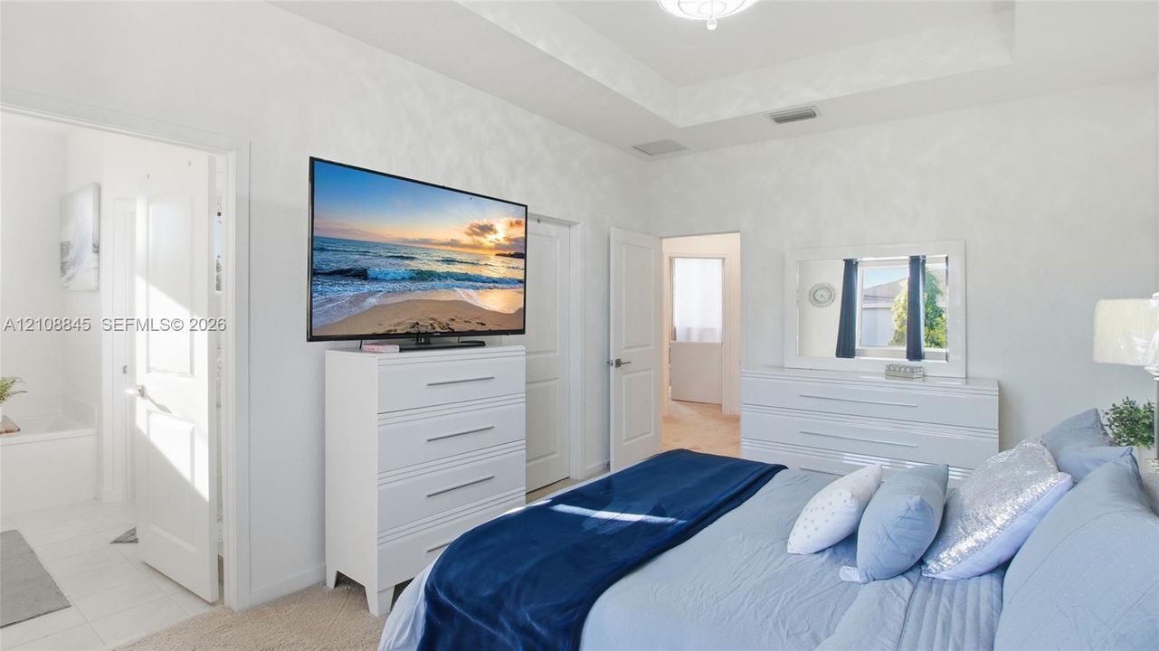 Tray ceiling with recessed lighting and neutral wall finishes