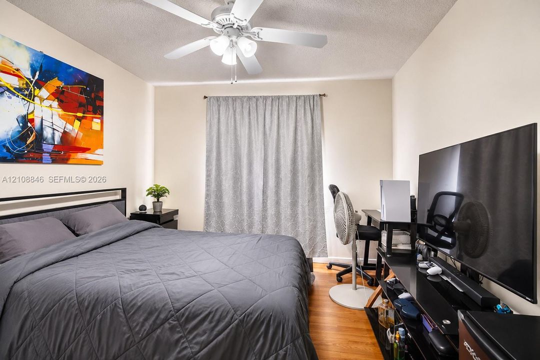 Room featuring wood-finish flooring, a ceiling fan with integrated lighting, and neutral wall tones