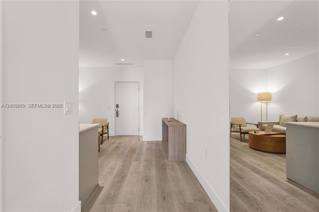 Wood-finish flooring throughout, recessed ceiling lighting, and solid core interior door with integrated hardware