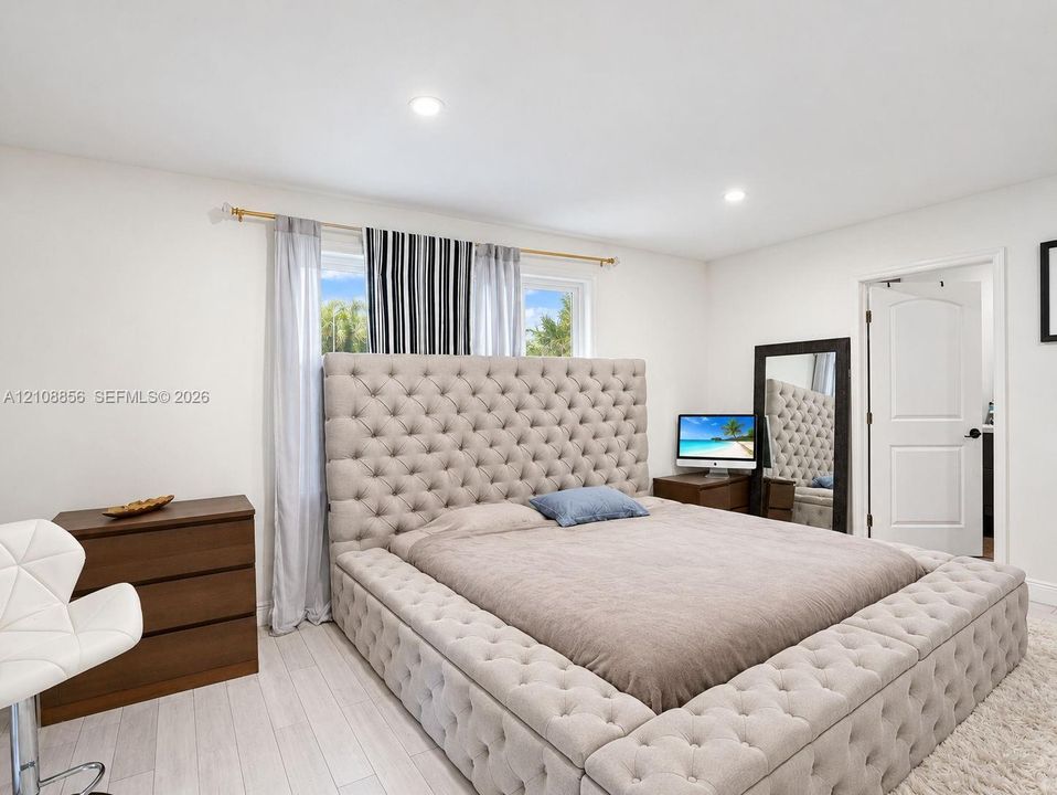 Neutral-toned wood-finish flooring, recessed lighting, and a multi-panel interior door