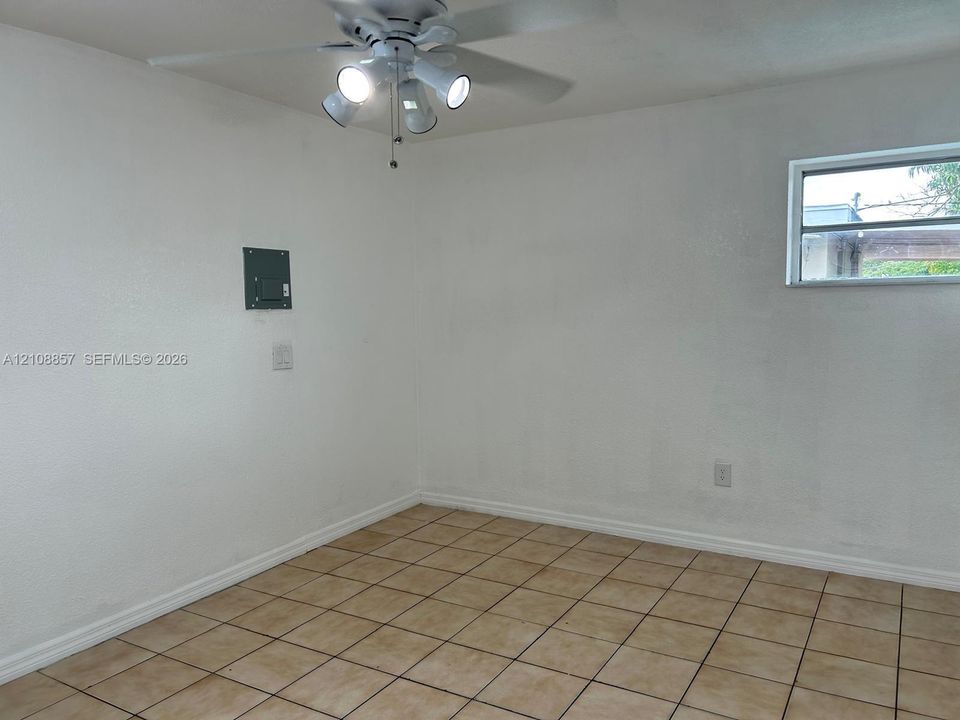 Interior space featuring ceramic tile flooring, a multi-light ceiling fan, and a single-pane horizontal window