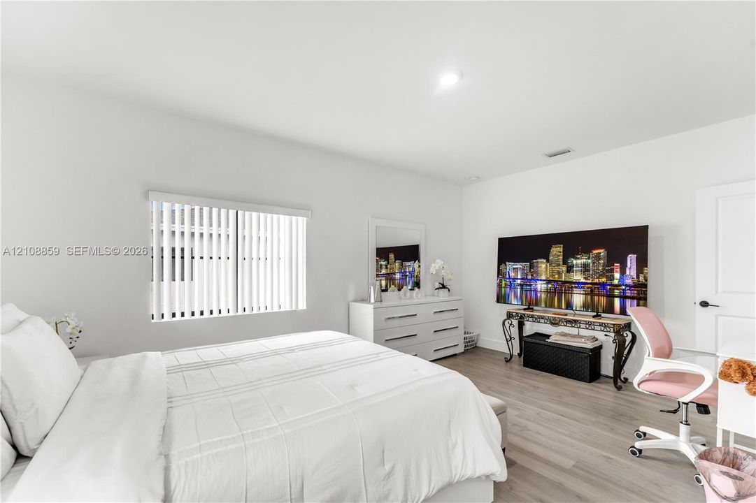 Neutral interior featuring wood-finish flooring, recessed lighting, and a single-panel interior door