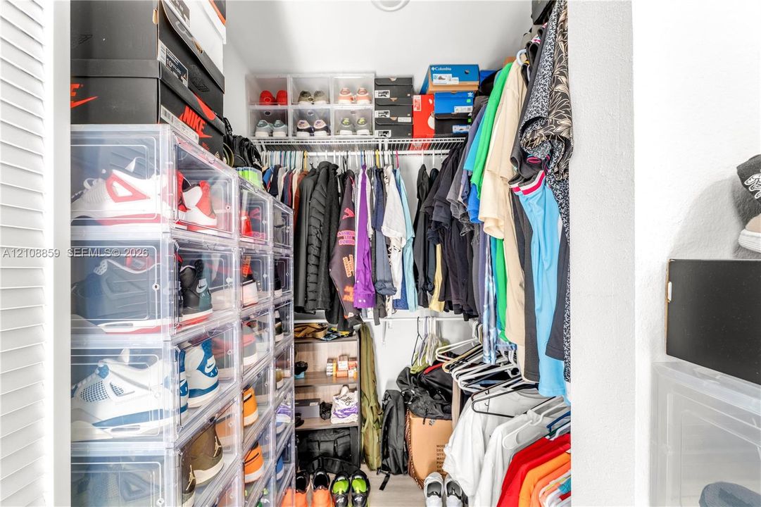 Reach-in closet featuring wire shelving and white louvered doors