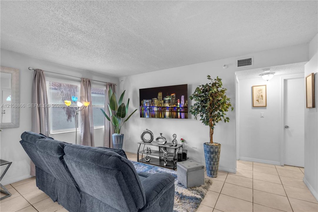 Living area featuring neutral wall paint, tile flooring, and dual-pane windows