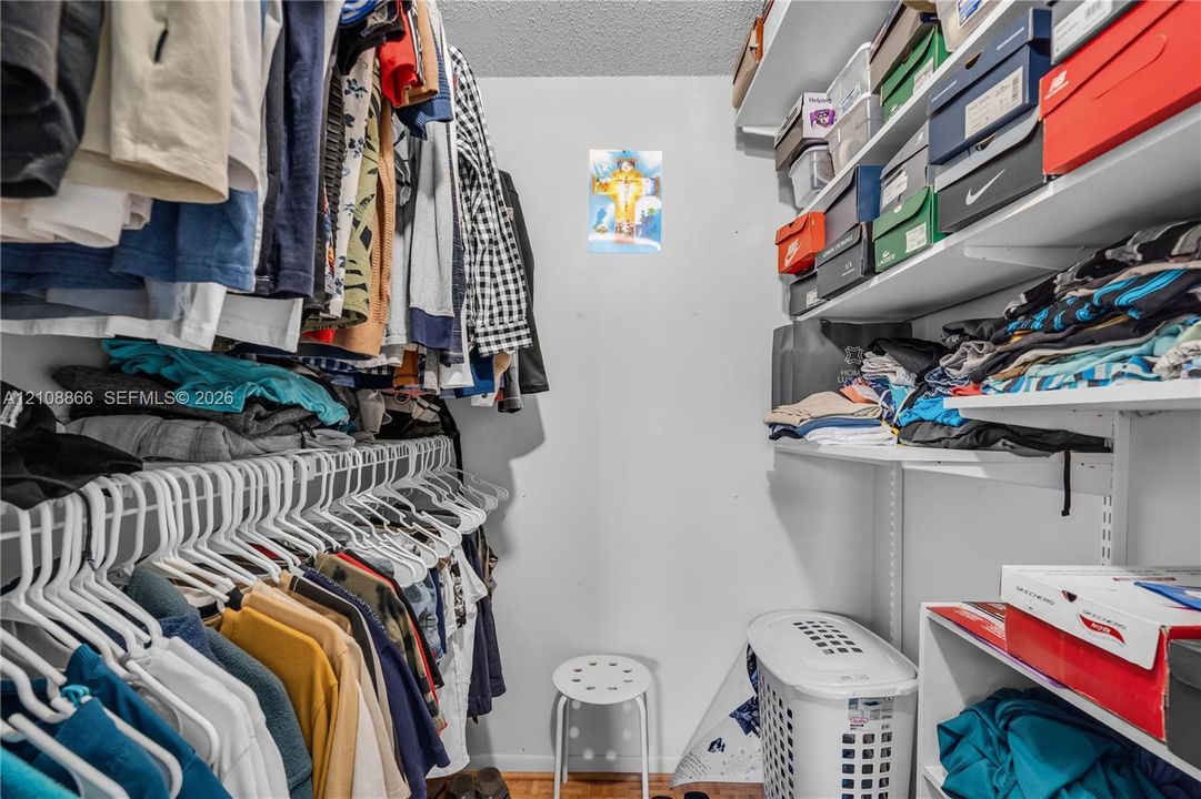 Walk-in closet featuring multi-tiered adjustable shelving and integrated hanging rods