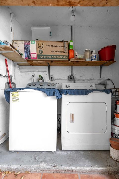 Laundry area featuring wall-mounted wooden shelving and concrete flooring