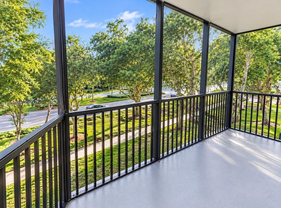 Screened-in balcony with dark metal framing, durable flooring, and vertical balustrades