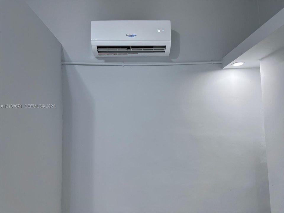 Wall-mounted ductless mini-split climate control unit with recessed ceiling lighting