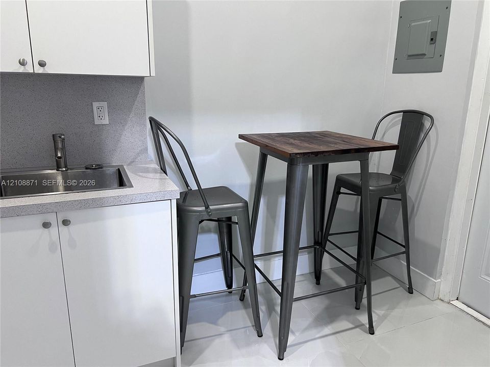 Built-in white cabinetry with solid-surface countertops, integrated stainless steel sink, and single-handle faucet