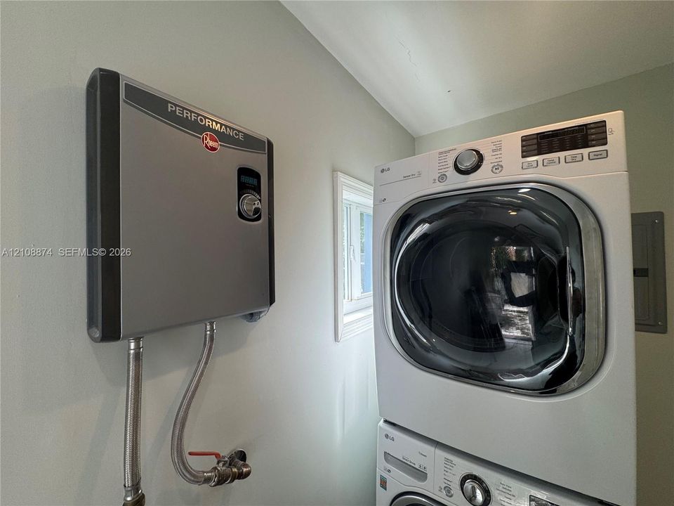 Tankless electric water heater and stacked laundry unit