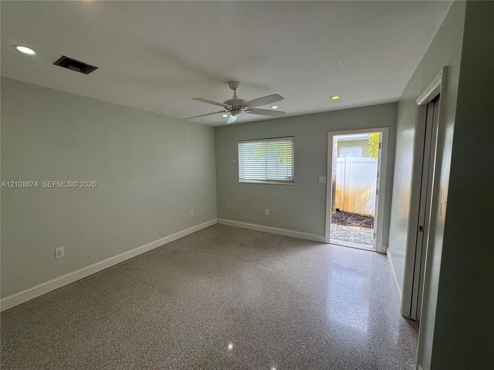Neutral-toned interior featuring terrazzo flooring, recessed lighting, a ceiling fan, and a glass-paneled exterior door