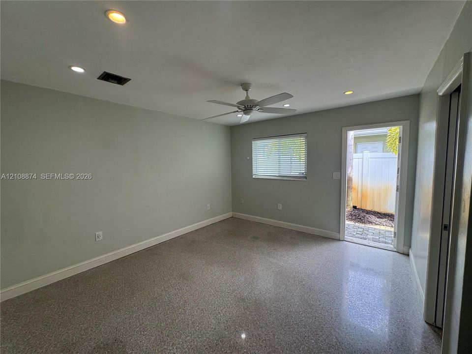 Interior space featuring speckled terrazzo flooring, recessed lighting, a ceiling fan, and direct exterior access via a glass-paneled door