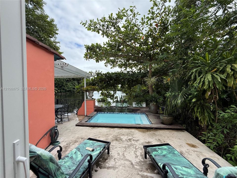 Patio space featuring an in-ground pool, decorative metal railings, and a pergola