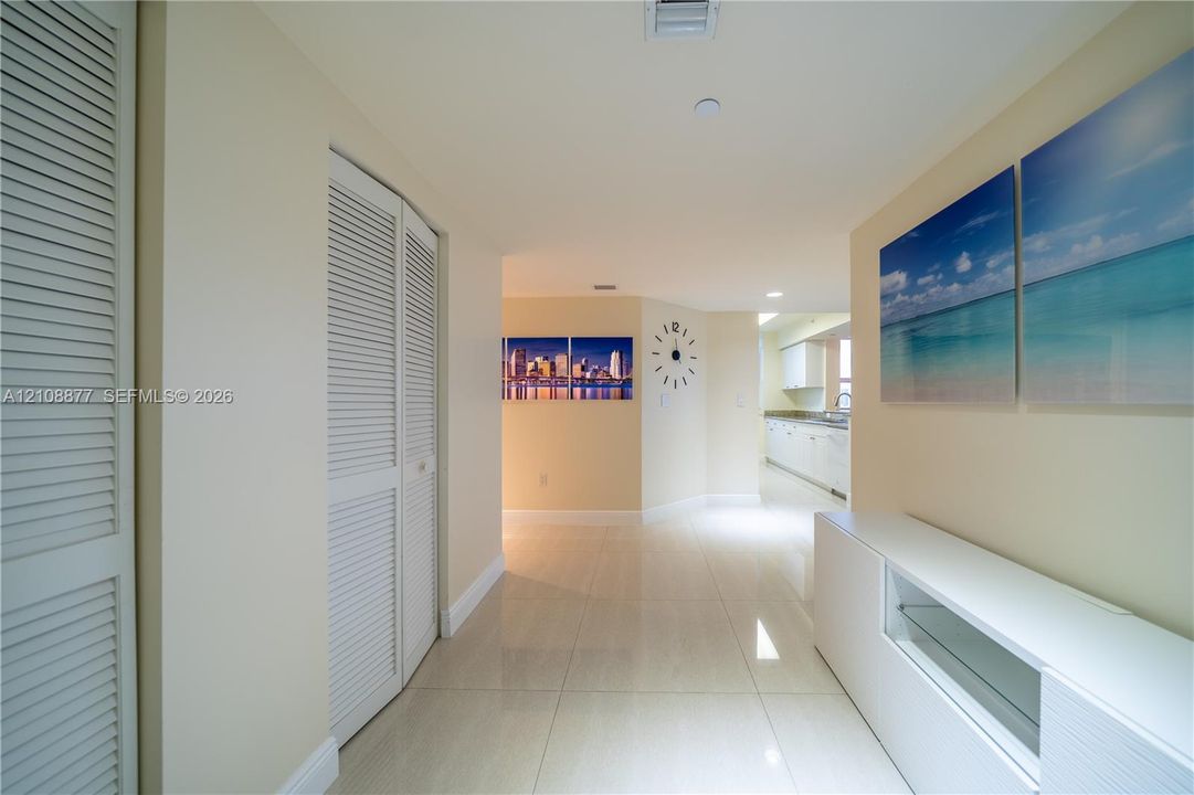 Interior space featuring polished tile flooring, white louvered closet doors, recessed lighting, and smooth-finish ceiling