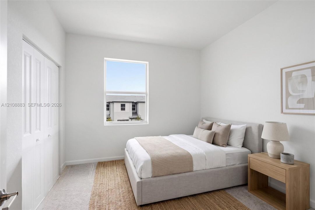 Neutral-toned interior featuring wall-to-wall carpeting, white bi-fold closet doors, and a single-hung window