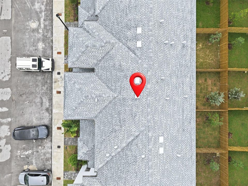 Aerial view of asphalt shingle roofing featuring multiple ridgelines and integrated vents