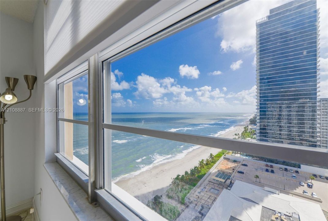 Large floor-to-ceiling windows featuring stone-topped sills and expansive ocean and coastal scenery