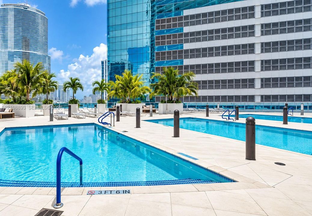 Multi-level outdoor pool deck featuring tile surround, built-in planters, and blue safety railings