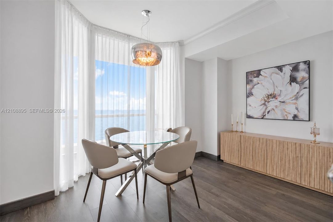 Bay window with floor-to-ceiling glass, wood-finish flooring, custom built-in cabinetry, and metallic pendant lighting