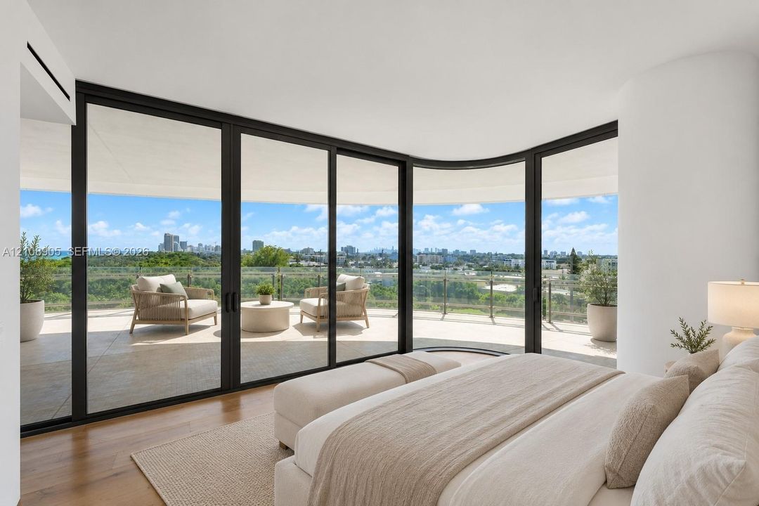 Curved floor-to-ceiling glass walls with black frames, wood-finish flooring, and a expansive wrap-around balcony featuring a glass railing