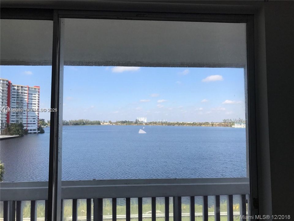 Floor-to-ceiling glass sliding door featuring a metal frame and integrated balcony railing
