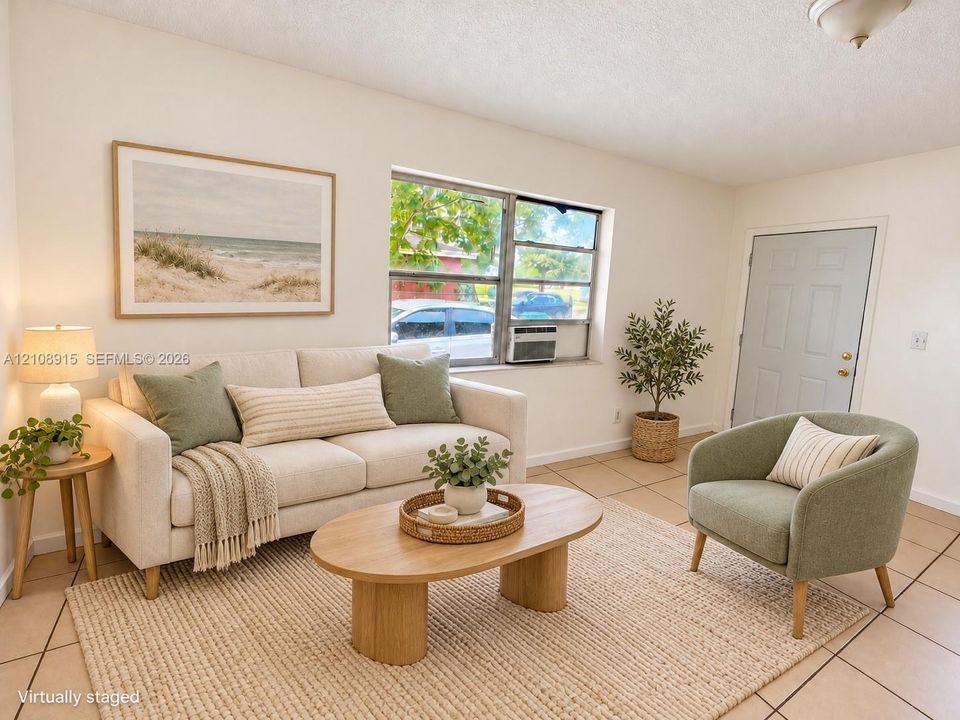 Neutral ceramic tile flooring, large multi-pane window with exterior natural light, and classic six-panel entry door