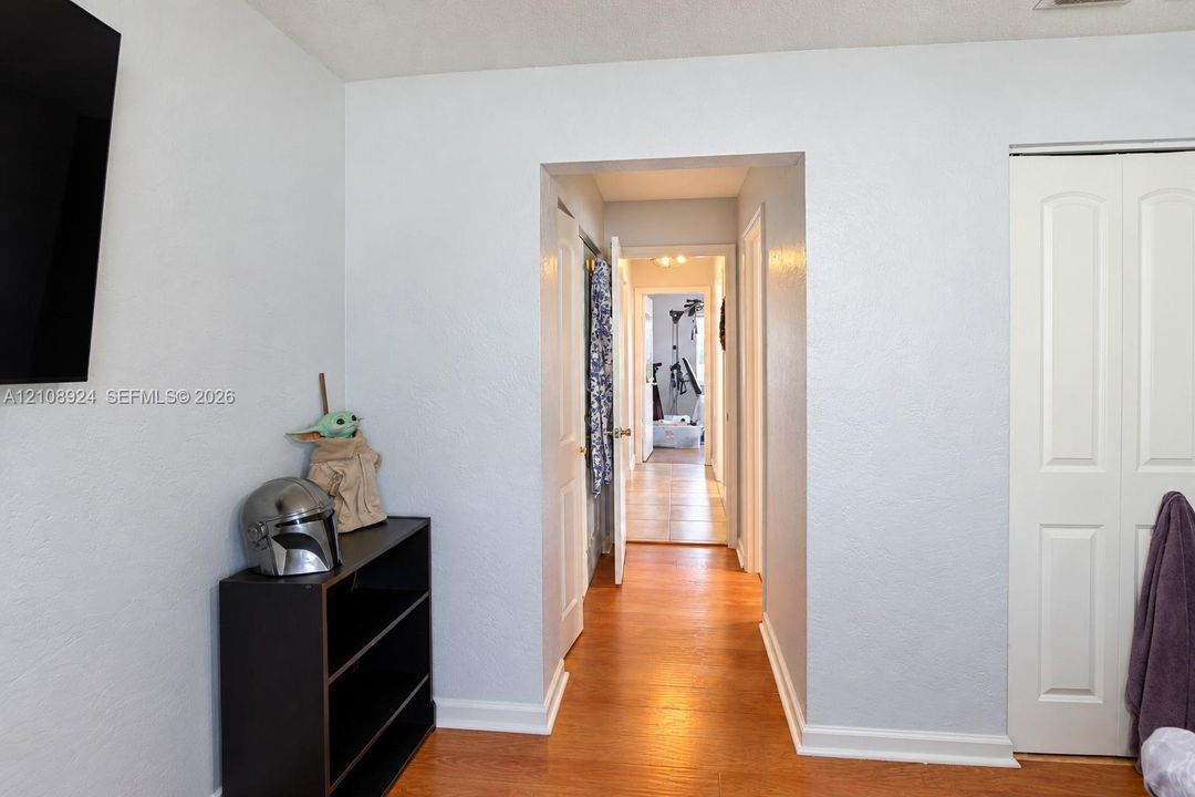 Interior space featuring wood-finish flooring, white walls, and a bi-fold closet door