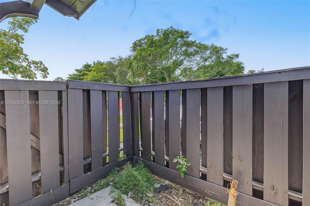 Dark-stained vertical wood privacy fencing featuring an enclosed perimeter