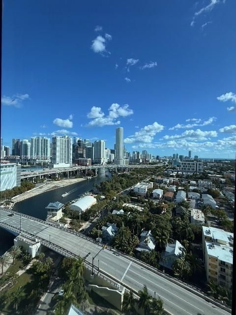 Elevated cityscape panorama featuring skyscraper architecture, waterway, and bridge infrastructure