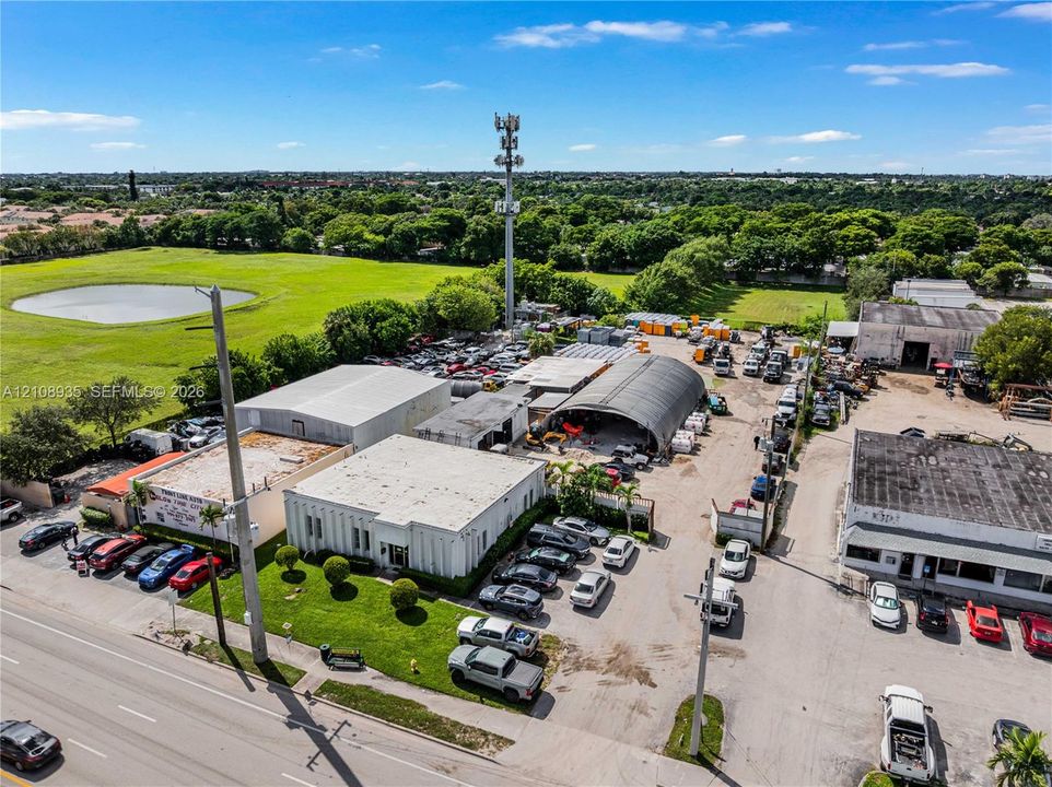 Industrial property featuring multiple structures, paved exterior surface area, and established perimeter landscaping