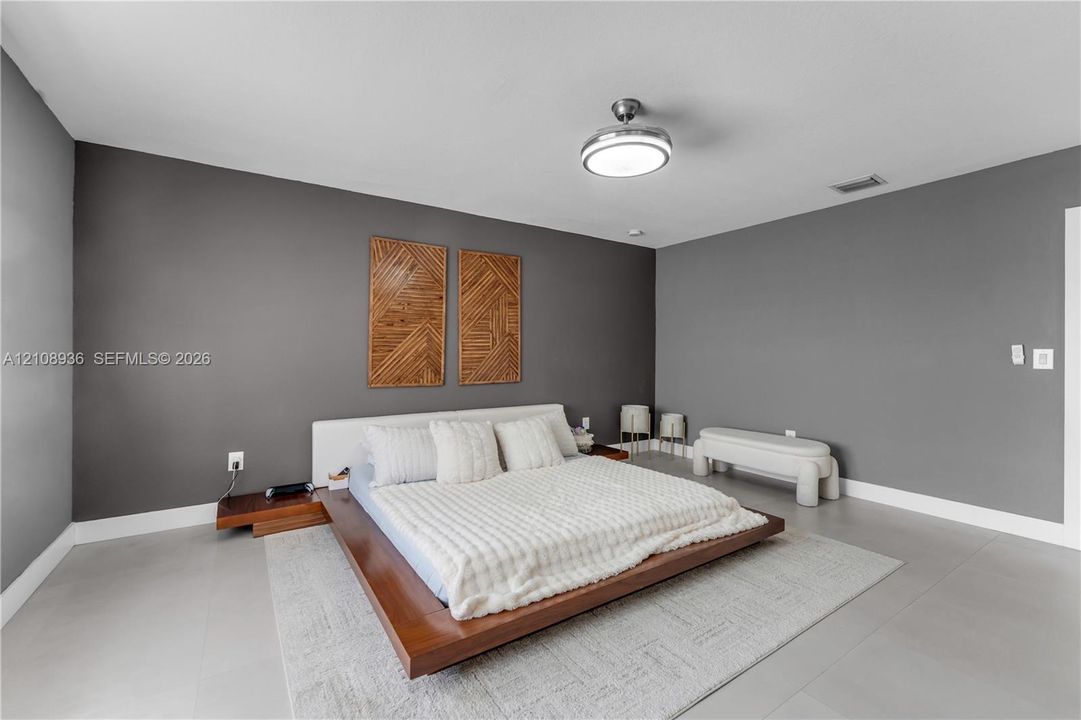 Neutral grey wall finish, large-format tile flooring, and integrated ceiling fan with central lighting