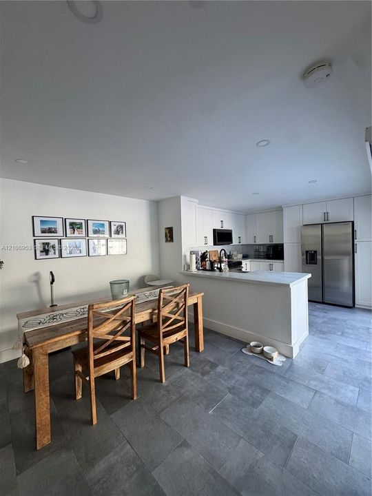 Kitchen featuring white shaker-style cabinetry, quartz countertops, a stainless steel side-by-side refrigerator, recessed lighting, and large-format tile flooring