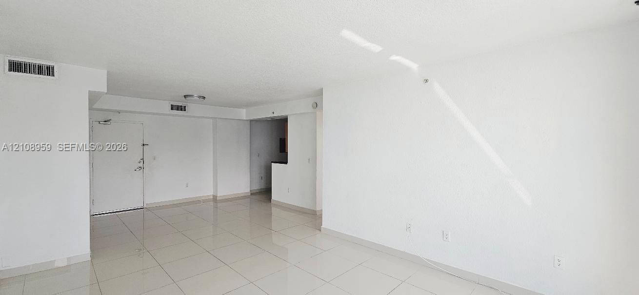 Open-concept interior featuring light-toned tile flooring, smooth wall finishes, and a neutral color palette