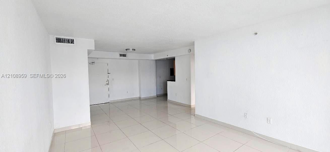 Open-concept interior featuring light-toned large-format tile flooring and neutral wall finishes