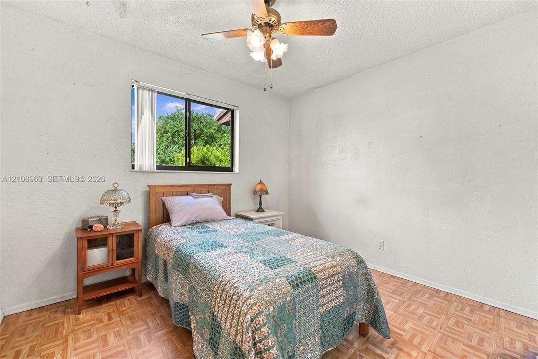 Parquet flooring, single-pane window, and ceiling-mounted light fixture with fan