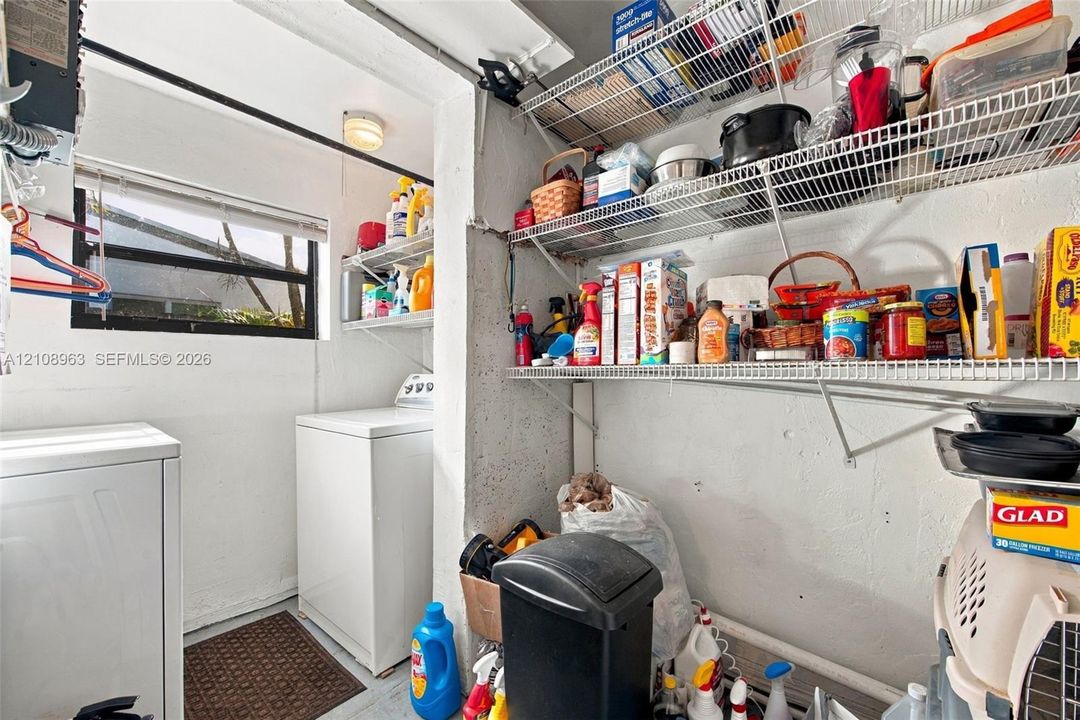 Utility room featuring a horizontal sliding window, wall-mounted wire shelving, and dedicated appliance hookups